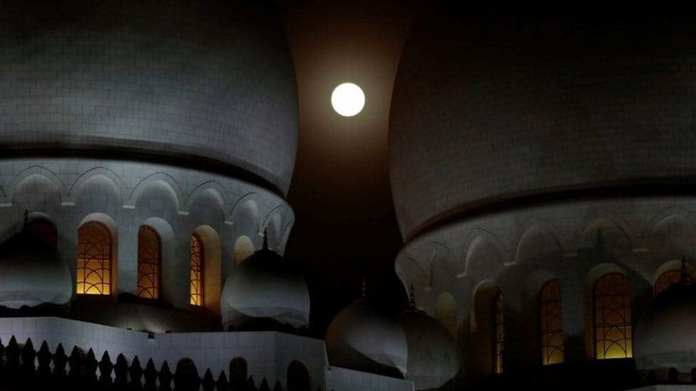 Abu Dhabi'de bulunan Şeyh Zayed Cami'sinin kubbeleri arasından Ay tutulmasının görünümü